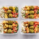 Pojemniki z wegańskim meal prep: falafel, ciecierzyca, ryż i warzywa